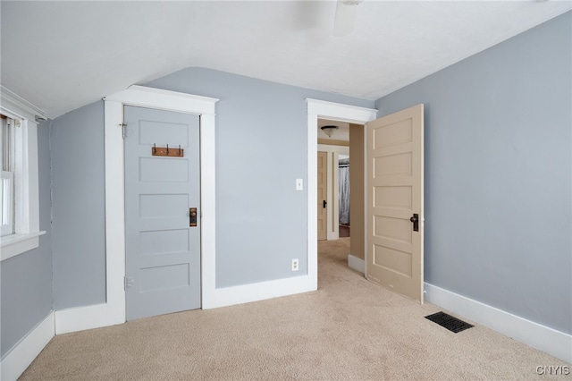 carpeted spare room featuring lofted ceiling