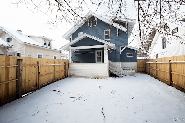 view of snow covered rear of property