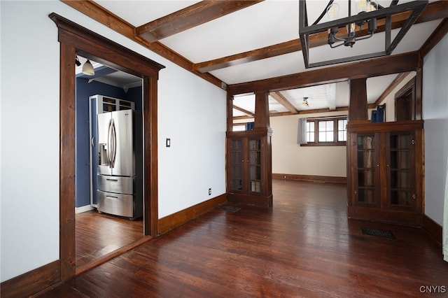 spare room featuring beamed ceiling, dark hardwood / wood-style flooring, and a chandelier