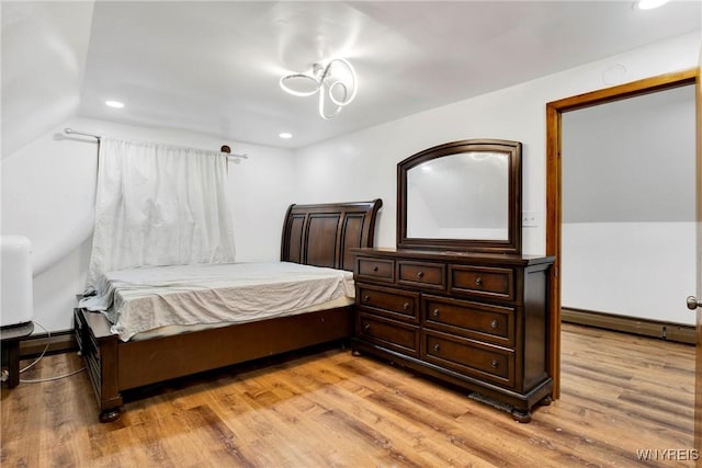 bedroom with light hardwood / wood-style flooring and baseboard heating