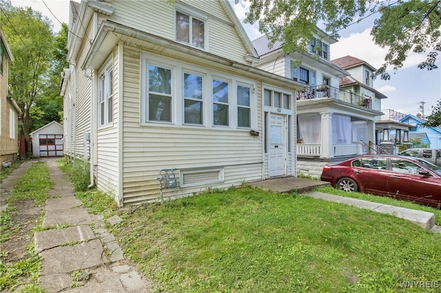 view of front of home featuring an outdoor structure and a front yard