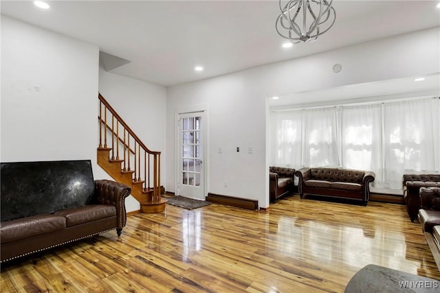 living room with wood-type flooring and an inviting chandelier