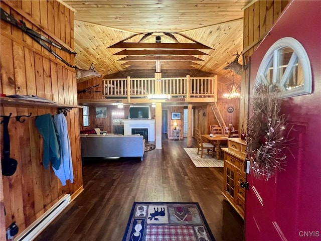 interior space with dark hardwood / wood-style flooring, high vaulted ceiling, a baseboard heating unit, wooden walls, and wood ceiling