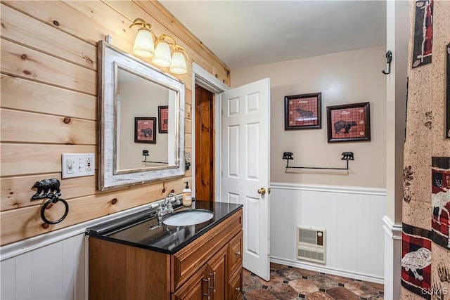 bathroom featuring vanity, wooden walls, and heating unit