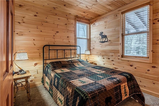 bedroom featuring wood ceiling, wooden walls, and carpet