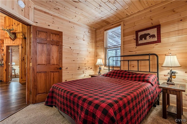 carpeted bedroom with wood ceiling and wood walls