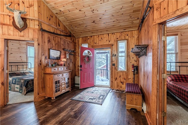 entrance foyer featuring lofted ceiling, dark hardwood / wood-style flooring, wooden ceiling, and wood walls