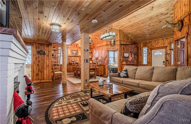 living room with plenty of natural light, lofted ceiling, wood ceiling, and wood walls