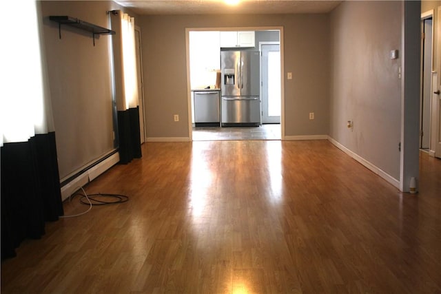 spare room featuring a baseboard radiator and wood-type flooring