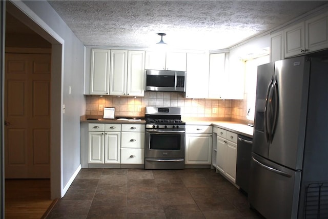 kitchen featuring decorative backsplash, white cabinets, stainless steel appliances, and a textured ceiling