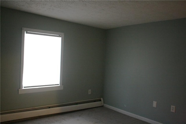 empty room featuring a textured ceiling and a baseboard radiator