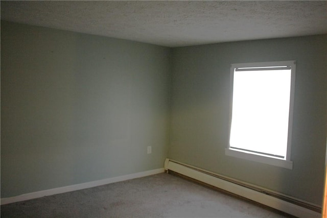 carpeted spare room featuring a baseboard radiator and a textured ceiling