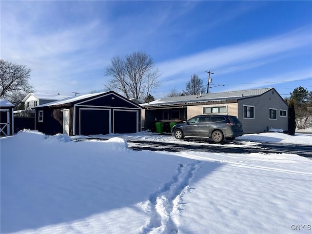 view of front of house featuring a garage and an outbuilding