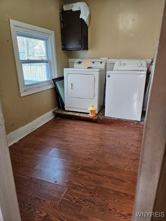 clothes washing area with cabinets, washer and dryer, and dark hardwood / wood-style flooring