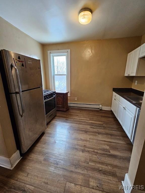 kitchen featuring appliances with stainless steel finishes, white cabinetry, baseboard heating, and dark wood-type flooring