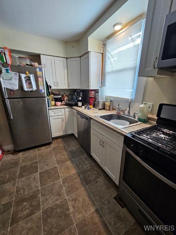 kitchen with white cabinets, stainless steel appliances, and sink