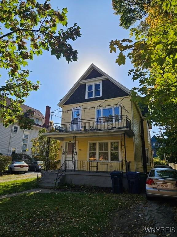 view of front of property featuring covered porch and a balcony