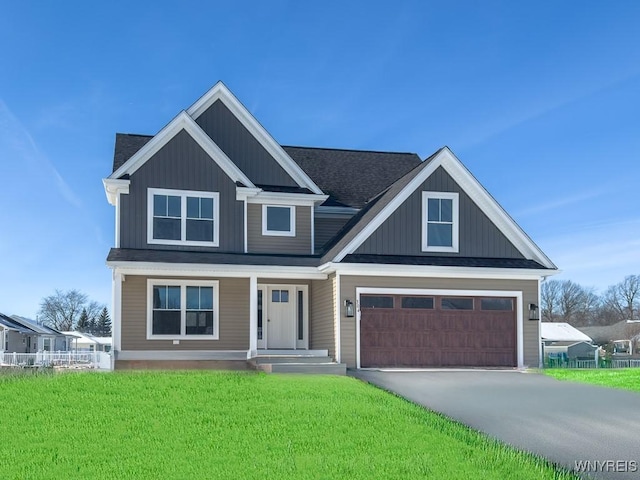 view of front facade featuring a garage, covered porch, and a front yard