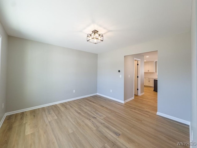 spare room with light wood-type flooring and baseboards