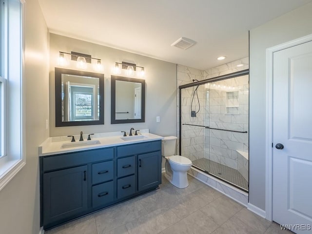 full bathroom featuring double vanity, visible vents, a stall shower, and a sink