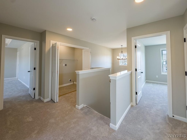 hall featuring baseboards, light colored carpet, an upstairs landing, recessed lighting, and an inviting chandelier