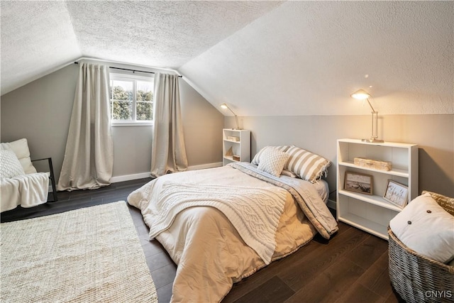 bedroom featuring dark hardwood / wood-style flooring, a textured ceiling, and vaulted ceiling