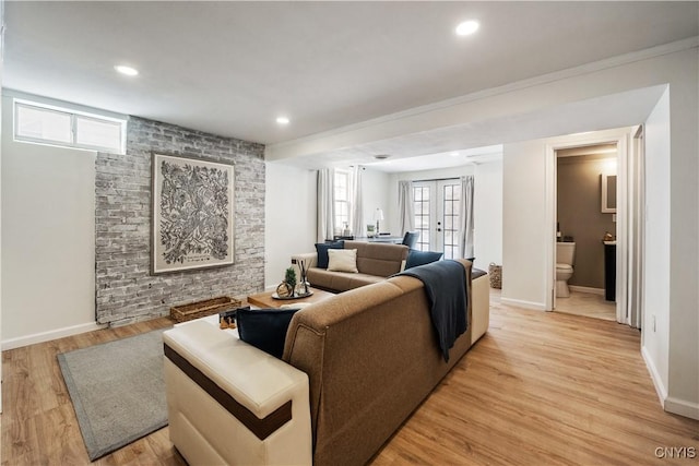 living room featuring light wood-type flooring, a wealth of natural light, and french doors