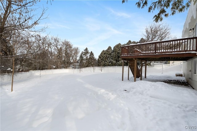 yard covered in snow featuring a deck