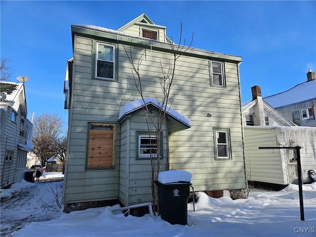 view of snow covered back of property