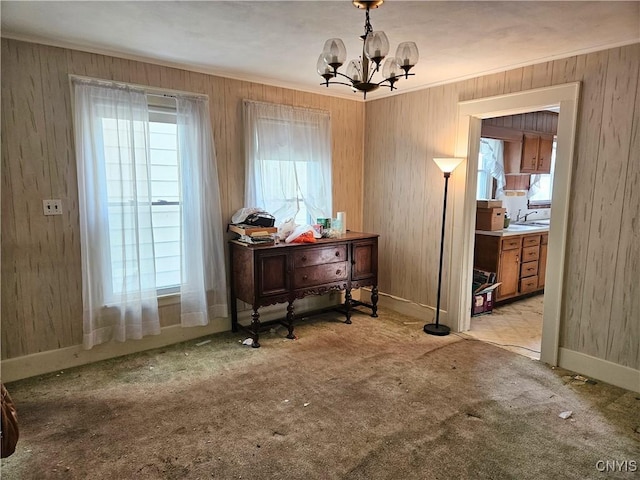 misc room featuring wood walls, sink, light colored carpet, and an inviting chandelier