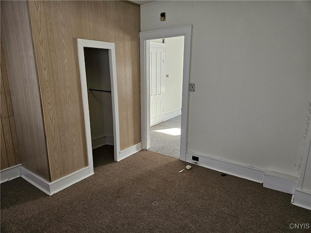 unfurnished bedroom with a closet and dark colored carpet