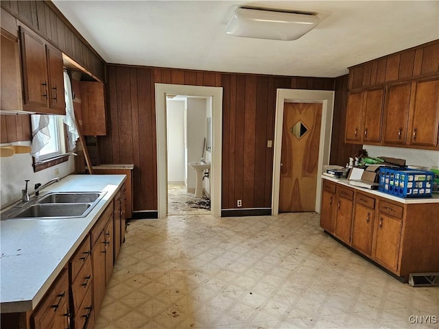 kitchen featuring sink and wooden walls