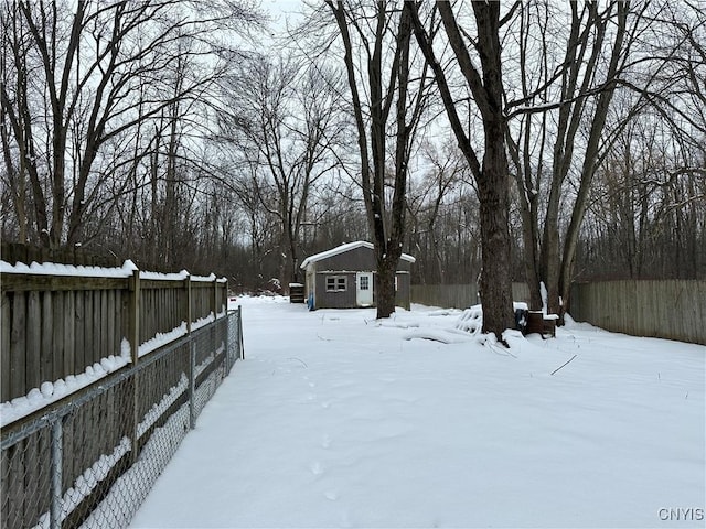 yard covered in snow with an outbuilding