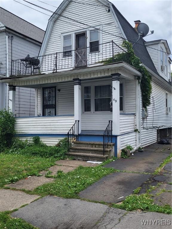 view of front of property with covered porch and a balcony