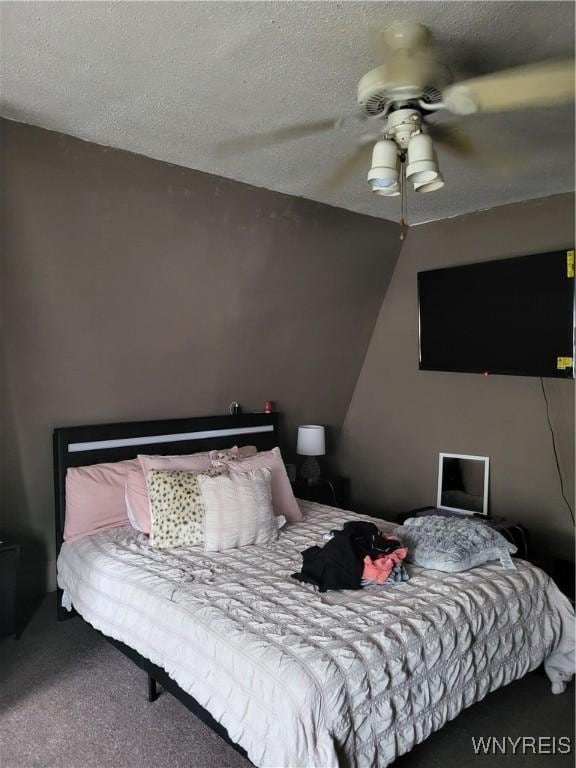 carpeted bedroom featuring a textured ceiling and ceiling fan