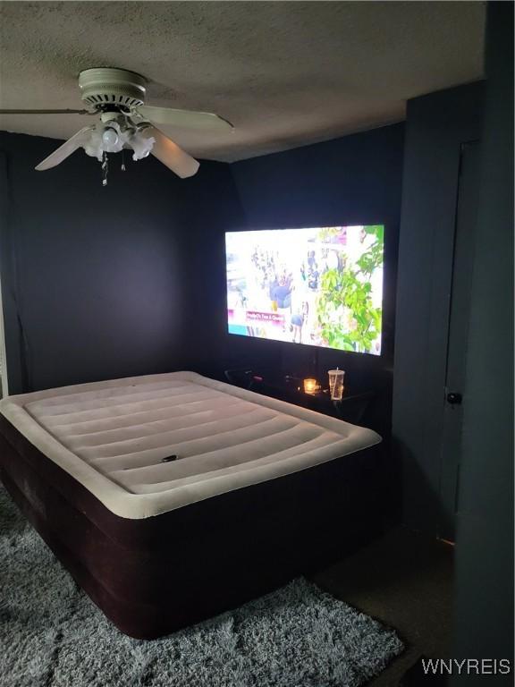 bedroom with a textured ceiling and ceiling fan