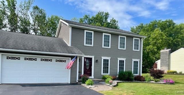 colonial house featuring a front yard and a garage