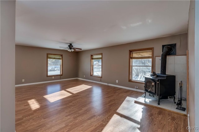 living room featuring hardwood / wood-style flooring, a wood stove, and ceiling fan