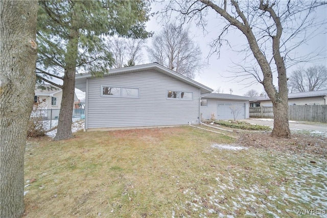 view of property exterior featuring a garage and a lawn