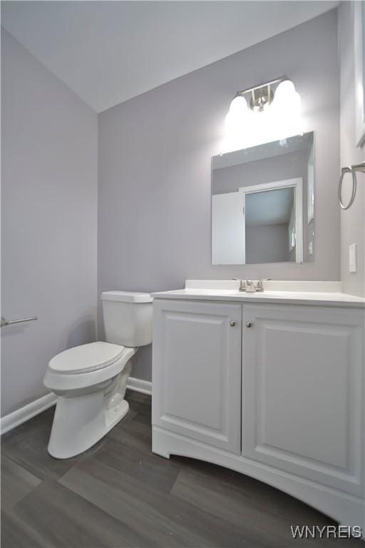 bathroom with toilet, wood-type flooring, and vanity