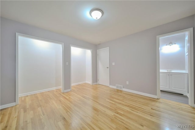 interior space with light wood-type flooring and ensuite bath