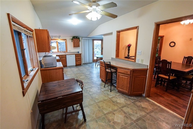 kitchen with lofted ceiling, ceiling fan, sink, and white dishwasher