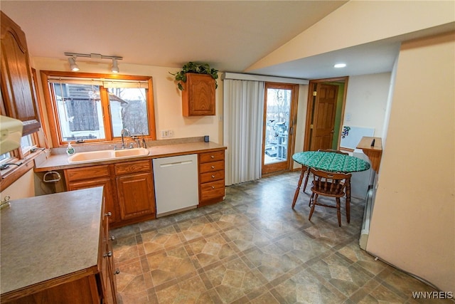 kitchen with white dishwasher, sink, and lofted ceiling