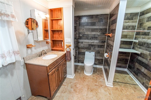 bathroom with toilet, vanity, and ornamental molding