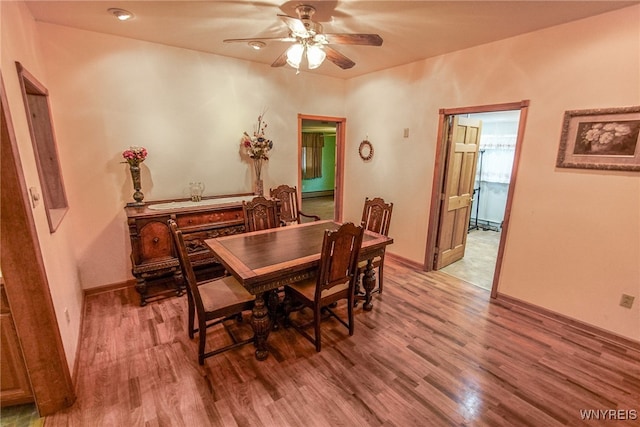 dining space with ceiling fan, wood-type flooring, and a baseboard heating unit