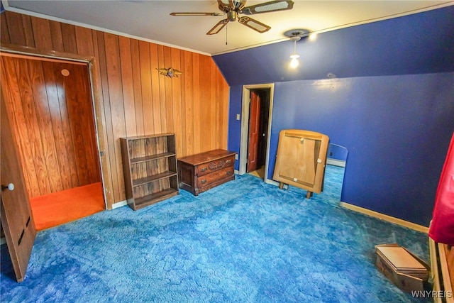 bedroom featuring ceiling fan, carpet floors, lofted ceiling, wood walls, and crown molding