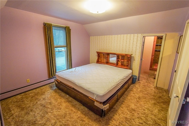 bedroom featuring lofted ceiling, a walk in closet, baseboard heating, and carpet floors