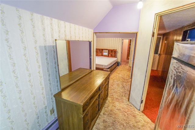 hallway with light colored carpet and lofted ceiling