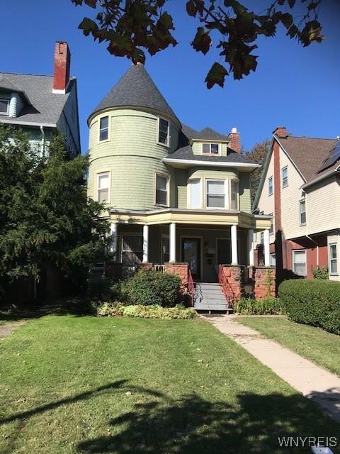 victorian home with a front lawn and covered porch