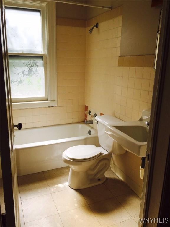 full bathroom featuring sink, tile patterned flooring, tiled shower / bath combo, and toilet